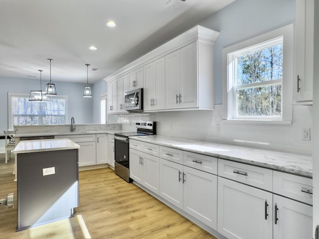 kitchen with white cabinetry, appliances with stainless steel finishes, sink, and decorative backsplash