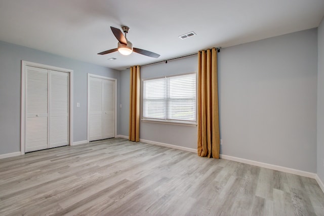 5043 Victoria Ave, North Charleston, SC 29405 - unfurnished bedroom featuring multiple closets, light wood-style floors, baseboards, and ceiling fan