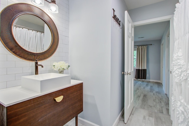 5043 Victoria Ave, North Charleston, SC 29405 - bathroom with baseboards, vanity, wood finished floors, and backsplash
