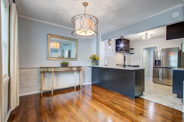 5043 Victoria Ave, North Charleston, SC 29405 - kitchen with stainless steel fridge, wood finished floors, a peninsula, ornamental molding, and light countertops