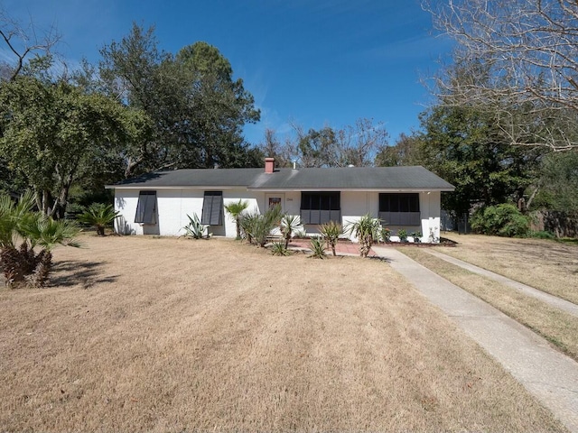 single story home featuring a chimney and a front yard