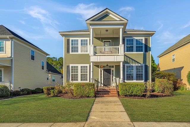 view of front of property featuring a balcony and a front lawn