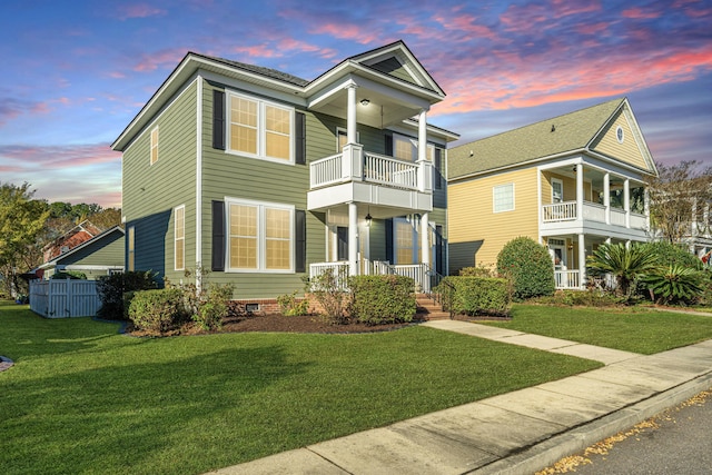 view of front facade with a yard, a balcony, and a porch