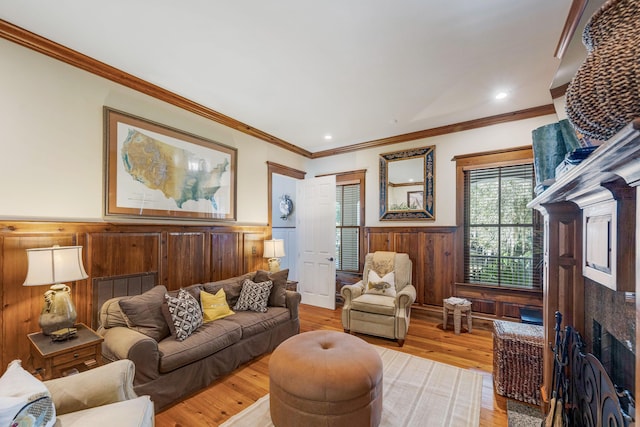 living room with light hardwood / wood-style floors, crown molding, and wooden walls