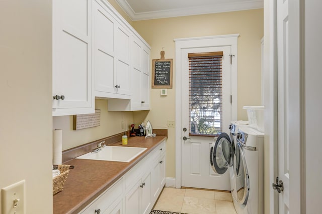 laundry room featuring cabinets, ornamental molding, sink, washer and dryer, and light tile patterned floors