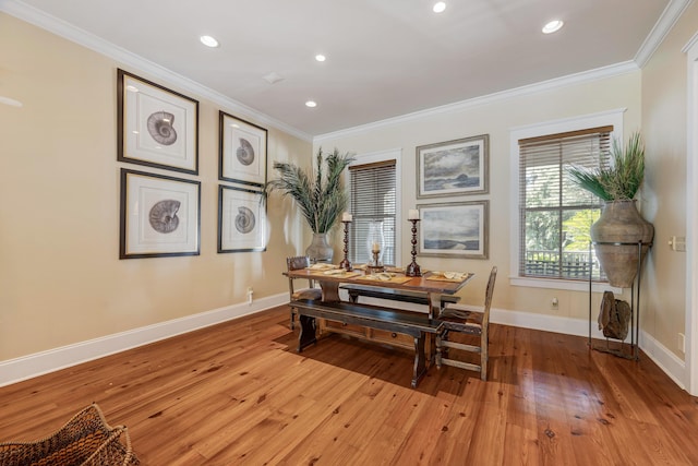 dining room with light hardwood / wood-style floors and crown molding