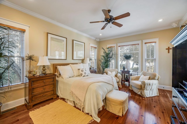 bedroom with dark hardwood / wood-style floors, ceiling fan, and ornamental molding