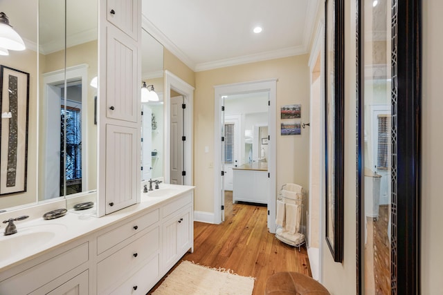 bathroom featuring hardwood / wood-style flooring, vanity, and crown molding