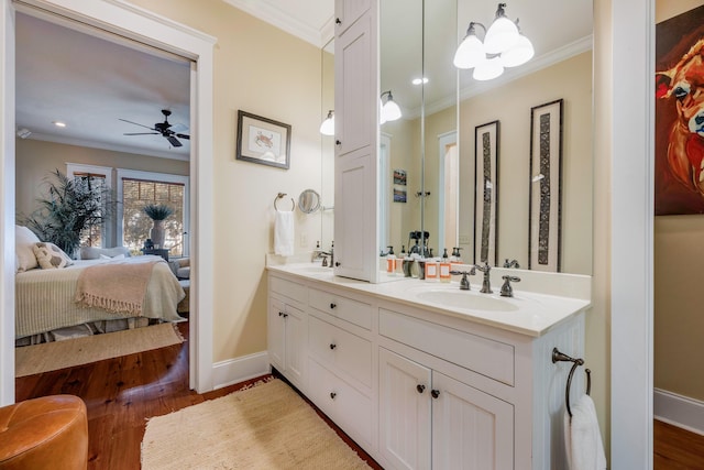 bathroom featuring hardwood / wood-style flooring, ceiling fan with notable chandelier, and ornamental molding