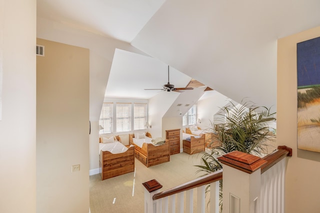 interior space featuring light carpet, ceiling fan, and vaulted ceiling