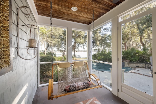 unfurnished sunroom featuring plenty of natural light and wooden ceiling