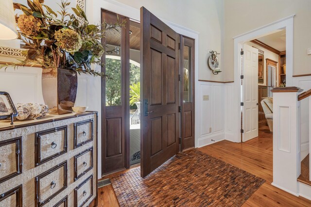 foyer entrance with light wood-type flooring and crown molding