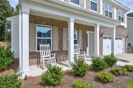 view of exterior entry with covered porch and a garage