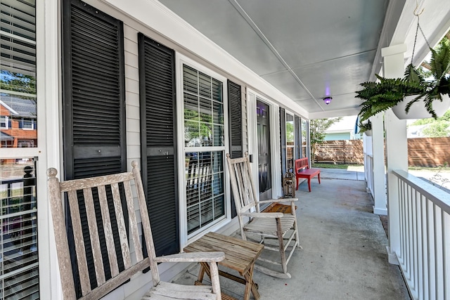 exterior space featuring a porch and fence