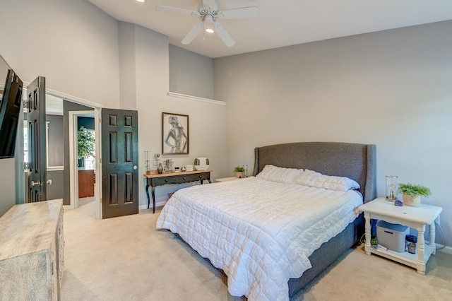 bedroom with ceiling fan, light colored carpet, baseboards, and a towering ceiling