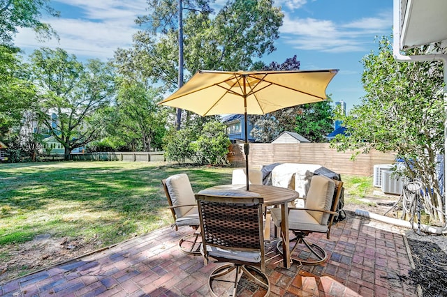view of patio with a fenced backyard, outdoor dining area, and central AC