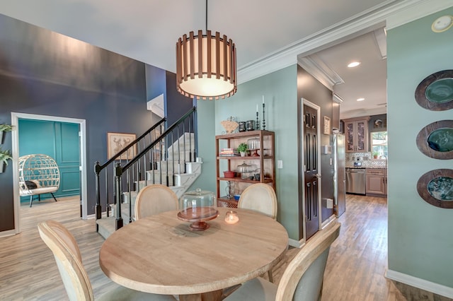 dining room featuring stairway, baseboards, light wood finished floors, ornamental molding, and recessed lighting