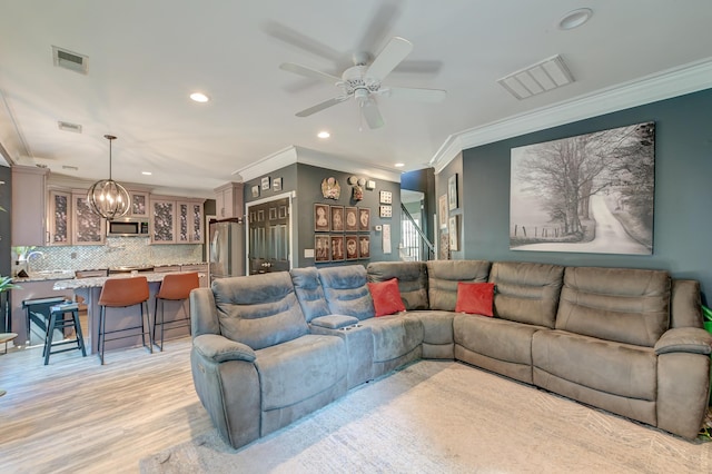 living area with ornamental molding, recessed lighting, and visible vents