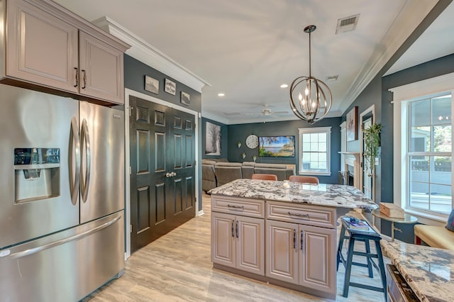 kitchen with ornamental molding, light stone countertops, stainless steel refrigerator with ice dispenser, light wood-style flooring, and a notable chandelier