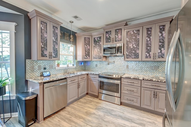 kitchen featuring light wood-style floors, decorative backsplash, stainless steel appliances, and visible vents
