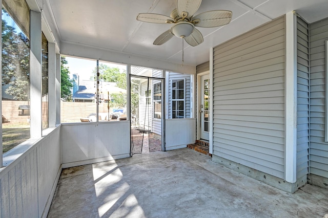 unfurnished sunroom featuring ceiling fan