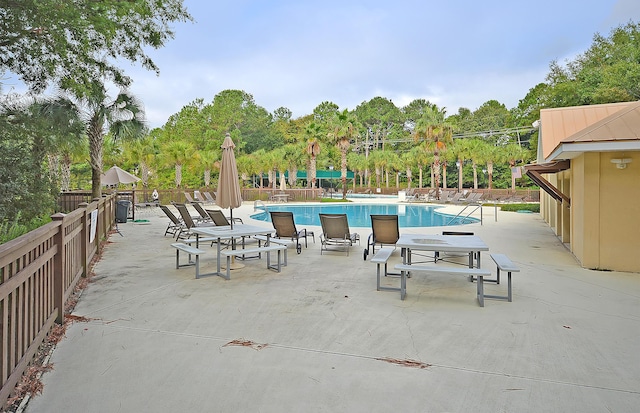 community pool featuring a patio and fence