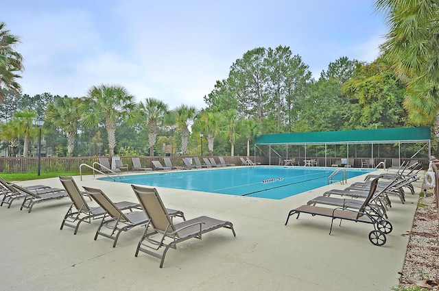 community pool with fence and a patio area
