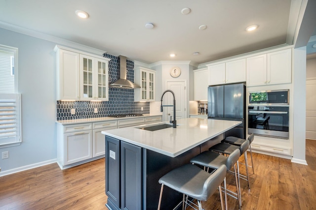 224 Wappoo Trace Ln, Summerville, SC 29486 - kitchen with stainless steel appliances, wall chimney range hood, a sink, a kitchen bar, and decorative backsplash
