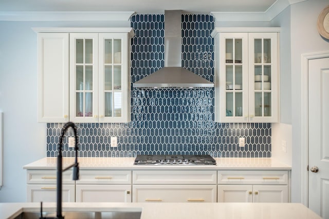 224 Wappoo Trace Ln, Summerville, SC 29486 - kitchen featuring stainless steel gas stovetop, wall chimney exhaust hood, backsplash, glass insert cabinets, and white cabinetry