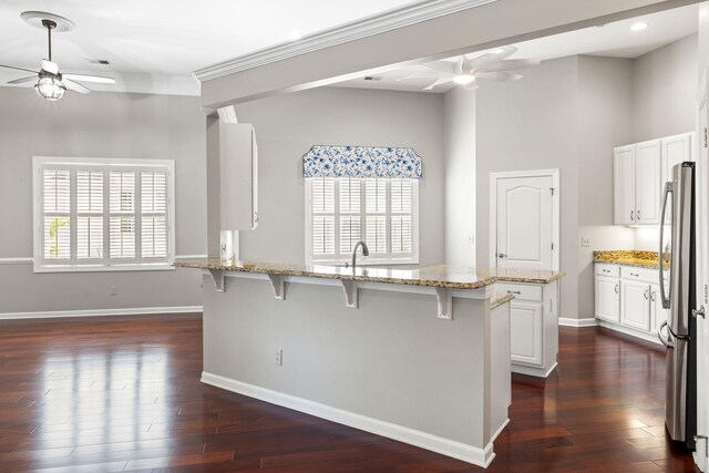 1232 Palmetto Peninsula Dr, Mount Pleasant, SC 29464 - kitchen with a ceiling fan, a kitchen bar, freestanding refrigerator, a peninsula, and ornamental molding