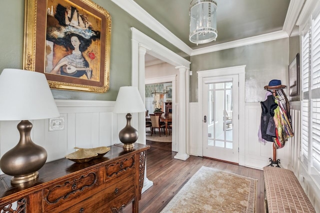 foyer with ornate columns, ornamental molding, and wood-type flooring