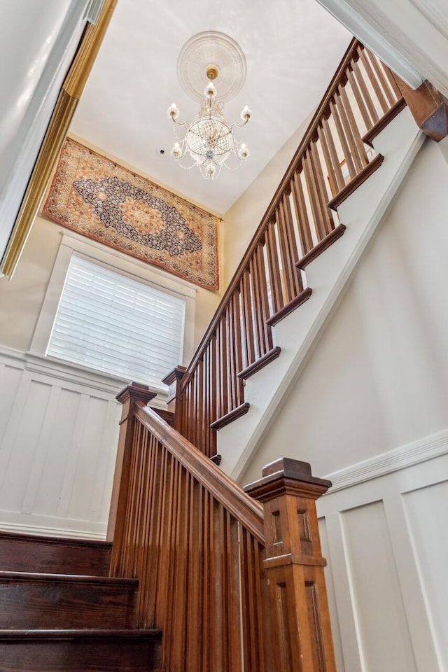 stairs featuring an inviting chandelier