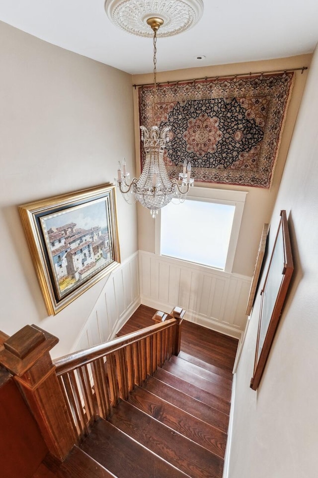 stairway featuring an inviting chandelier and hardwood / wood-style floors