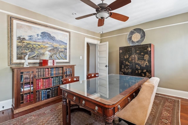 dining space with dark wood-type flooring and ceiling fan