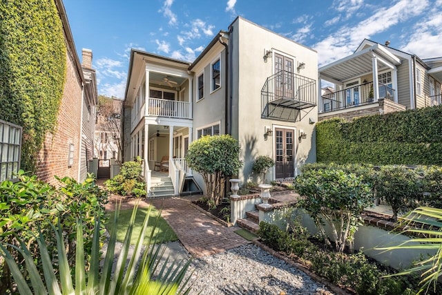 view of front of home featuring ceiling fan and a balcony