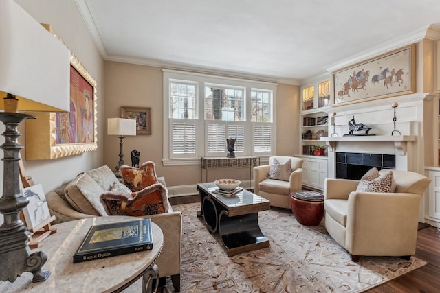 living room featuring hardwood / wood-style floors, crown molding, and a fireplace