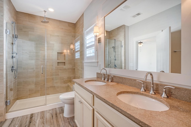 bathroom featuring toilet, a shower stall, visible vents, and a sink