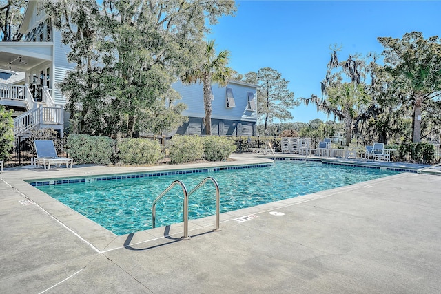 pool featuring stairs, a patio, and fence