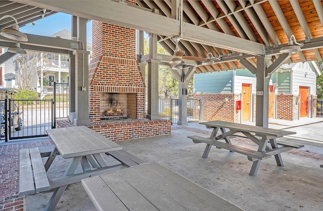 view of patio / terrace featuring an outdoor brick fireplace and a gazebo