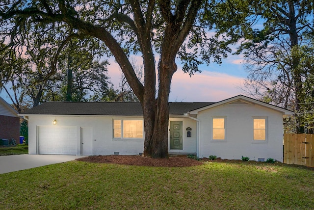 single story home featuring a garage and a lawn