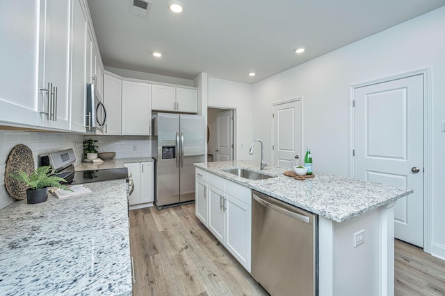 kitchen with white cabinetry, sink, stainless steel appliances, and a center island with sink