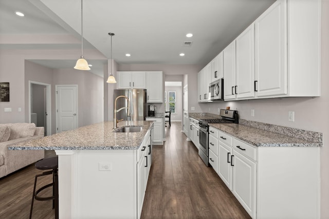 kitchen with white cabinetry, appliances with stainless steel finishes, decorative light fixtures, and sink