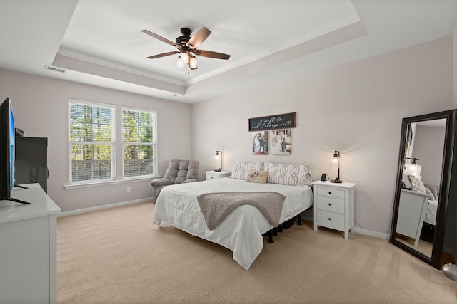 carpeted bedroom featuring crown molding, ceiling fan, and a raised ceiling