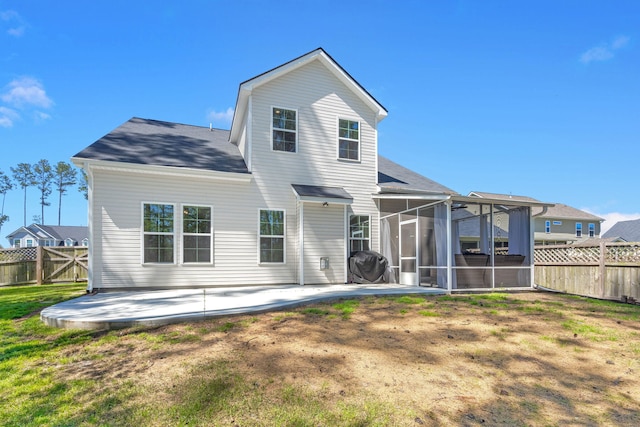 back of house with a sunroom, a lawn, and a patio area