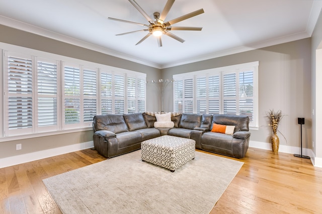 living room with light wood-style flooring, ornamental molding, and baseboards