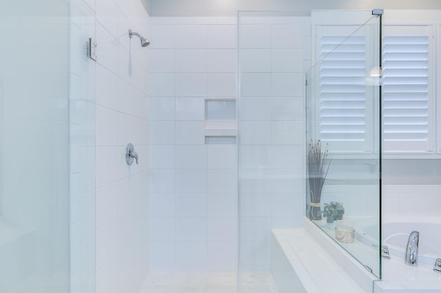 full bathroom featuring a shower stall and a bath