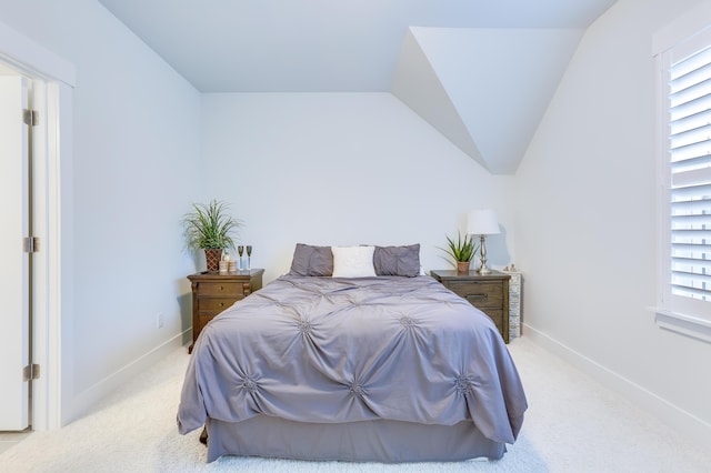 bedroom with light carpet, baseboards, and vaulted ceiling