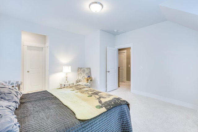 bedroom with lofted ceiling, light colored carpet, and baseboards