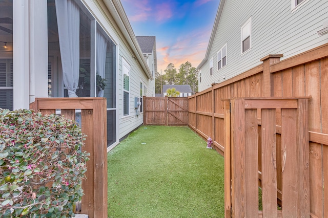 yard at dusk with a gate and fence