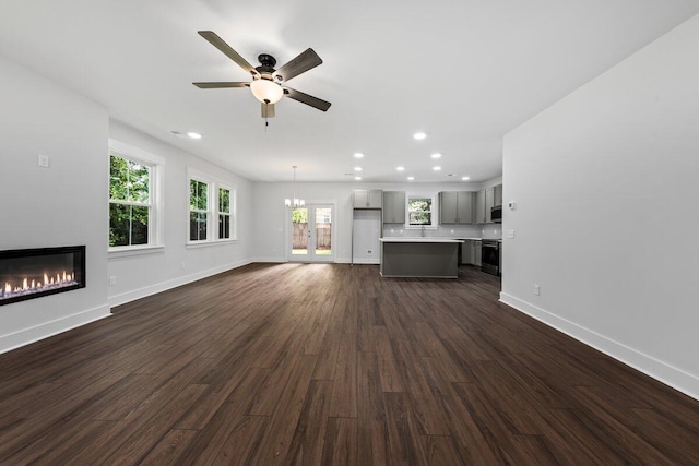 unfurnished living room featuring ceiling fan and dark wood-type flooring